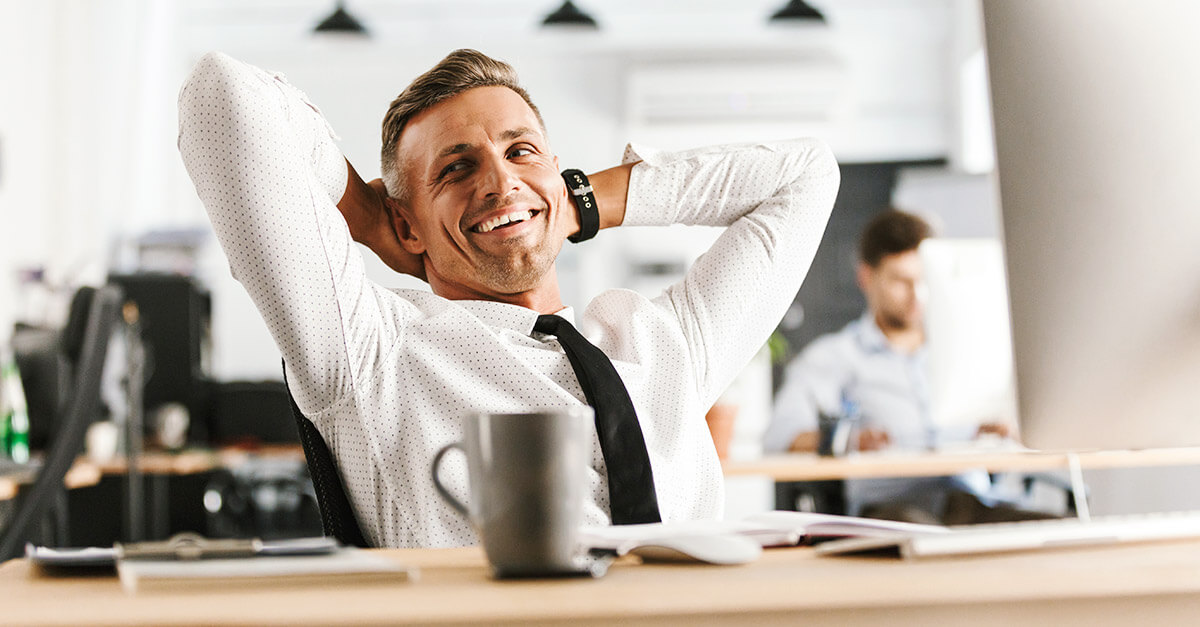 Mitarbeiter im Büro entspannt sich am Schreibtisch, thematisiert Prozesssicherheit im Mittelstand.