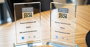 Zwei Awards für Asseco Solutions als ERP-System des Jahres 2026 auf einem Holztisch.