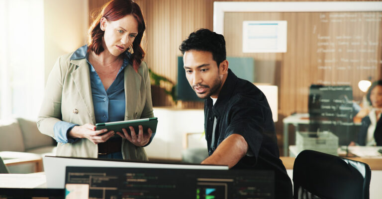 Geschäftsleute diskutieren über Low-Code-ERP-Lösungen im Büro, potenziell von Asseco Solutions.